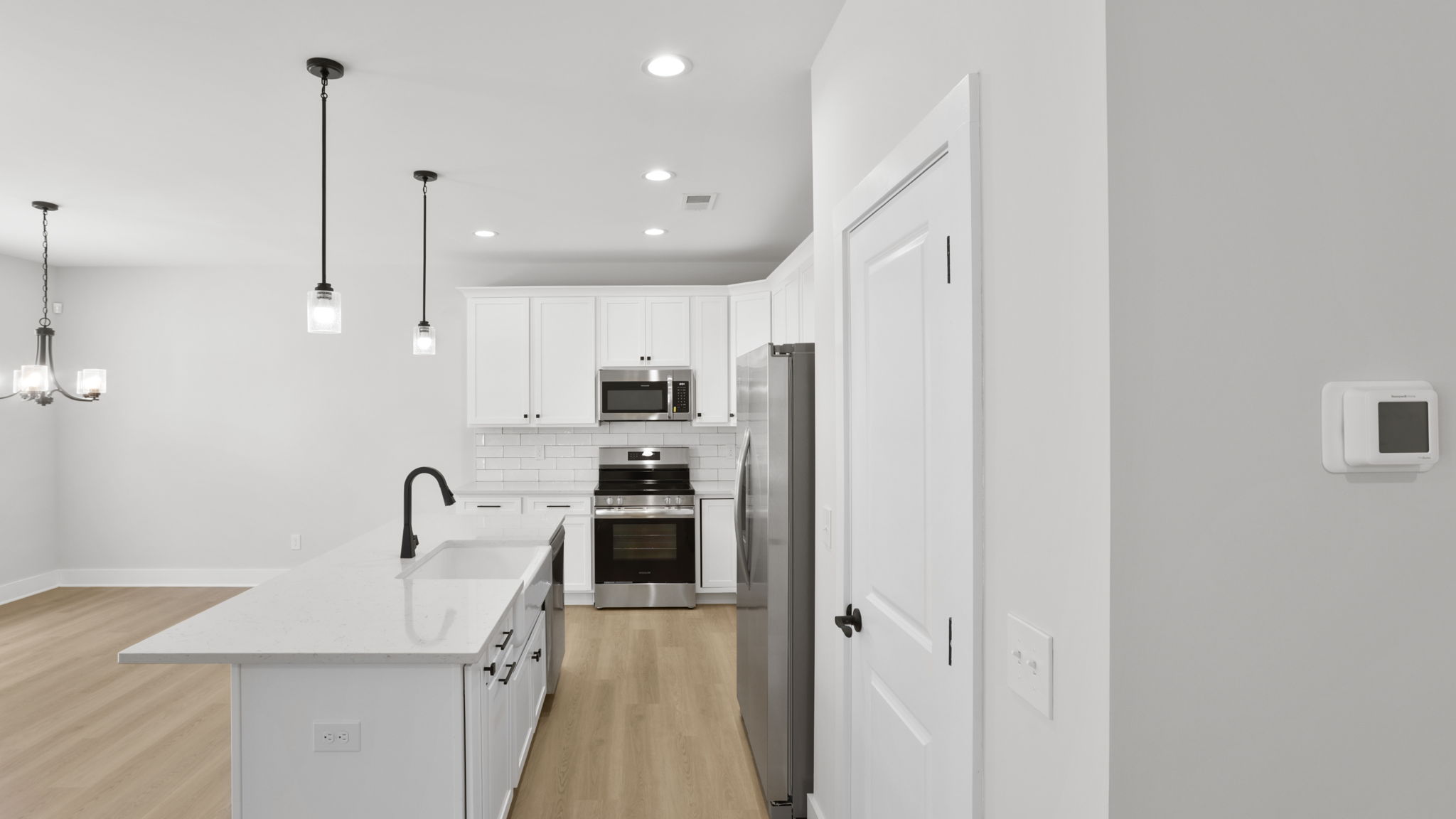 Kitchen and island with stainless steel appliances.