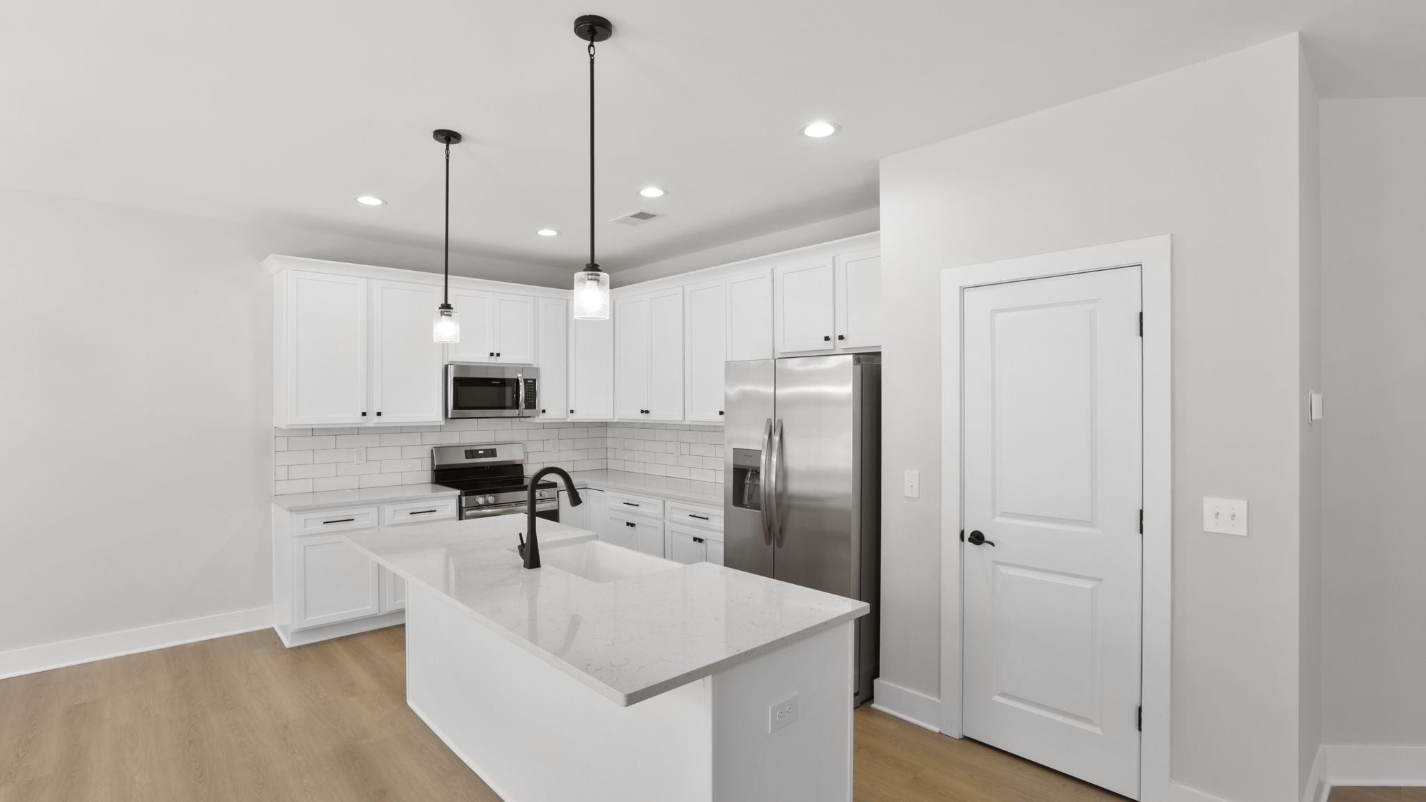 Kitchen and island with stainless steel appliances.