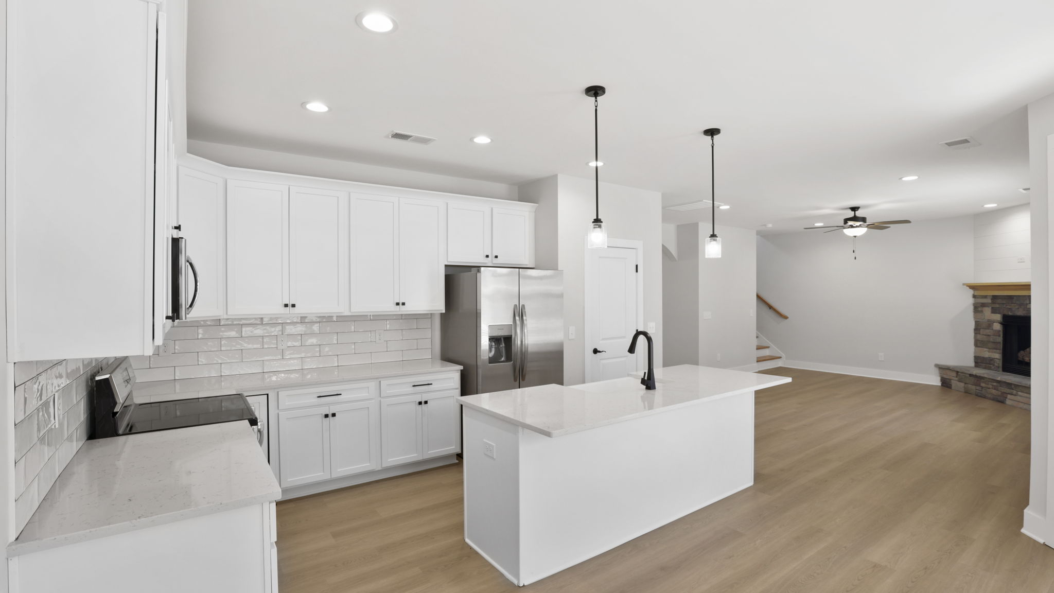 Kitchen and island with stainless steel appliances.
