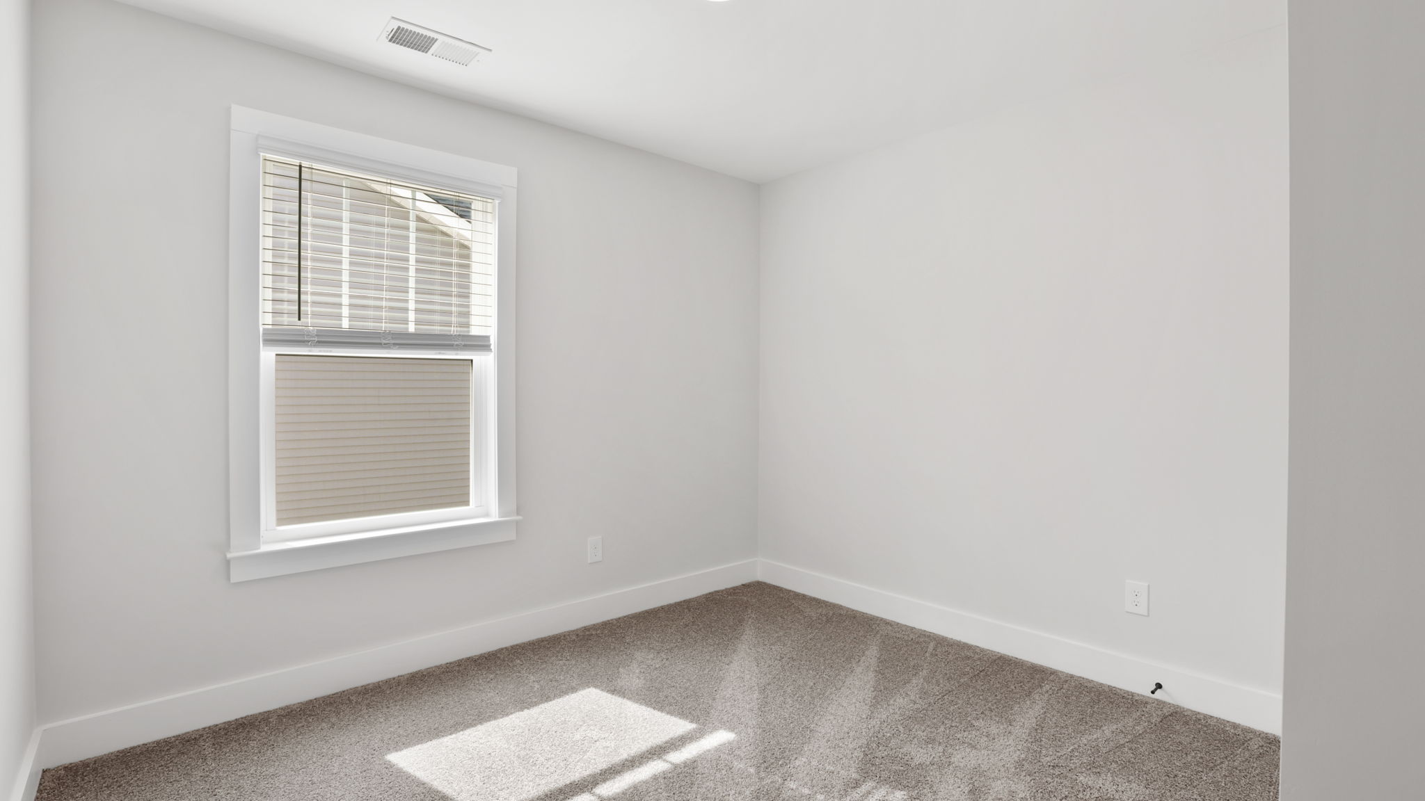 Bedroom with carpet and window.