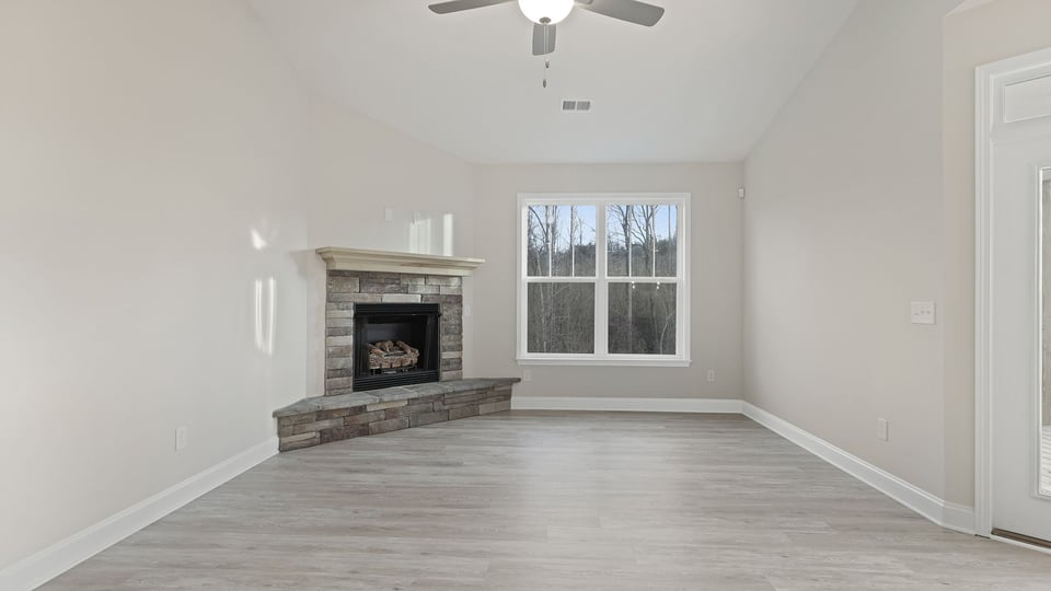Family room with large window and gas fireplace.