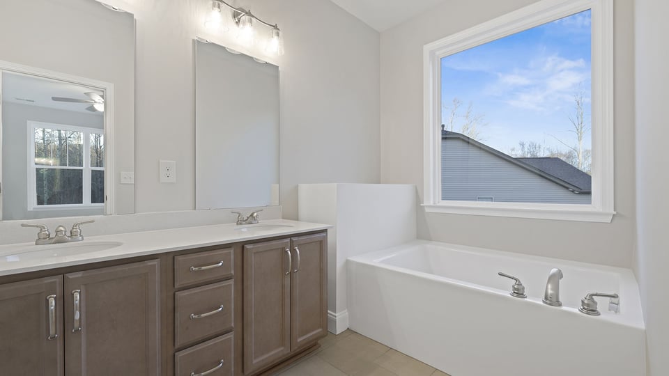 Primary bathroom with dual sink vanity and garden tub.