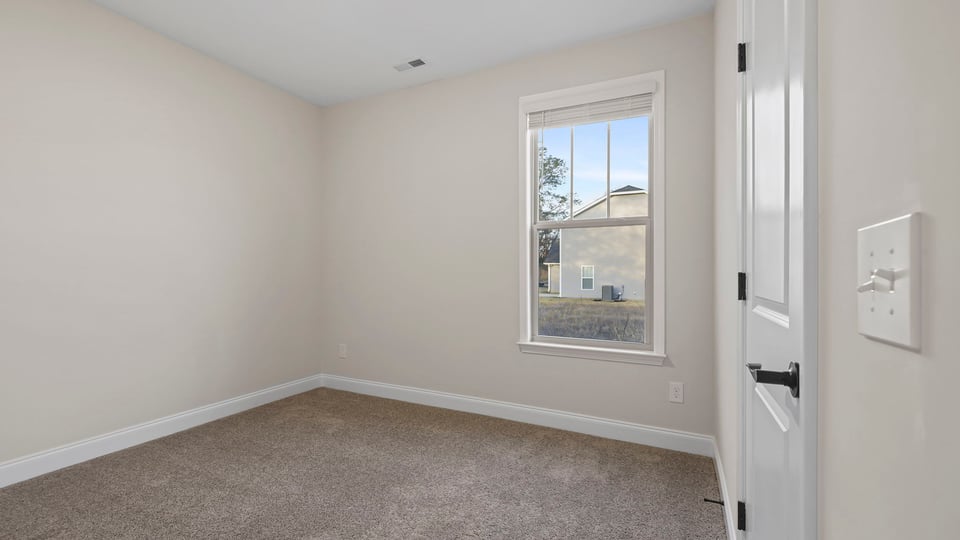 Bedroom with carpet and window.