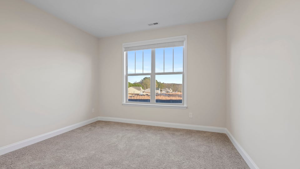 Bedroom with carpet and window.