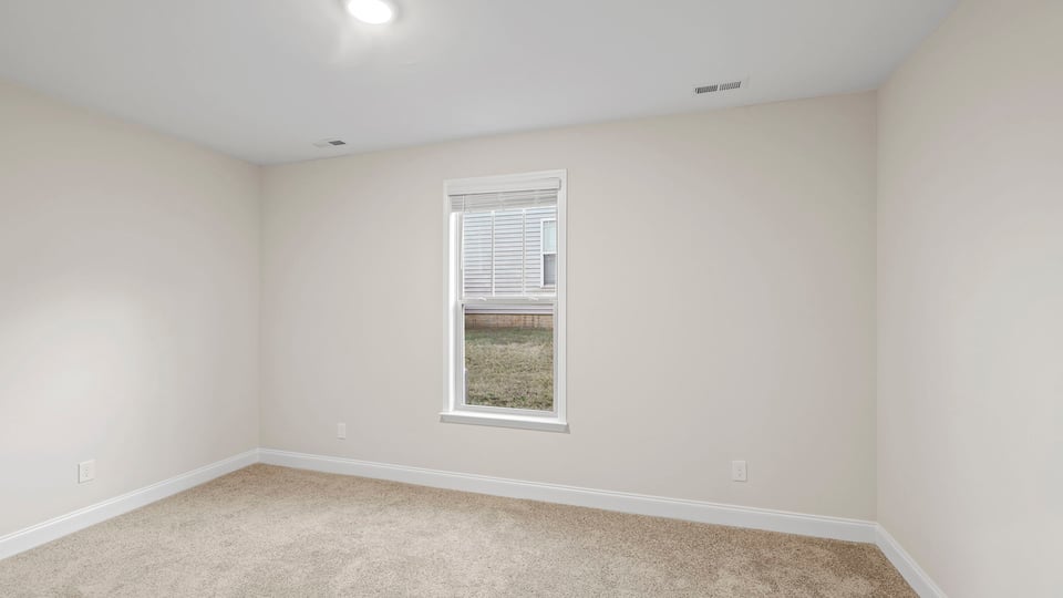 Bedroom with carpet and window.