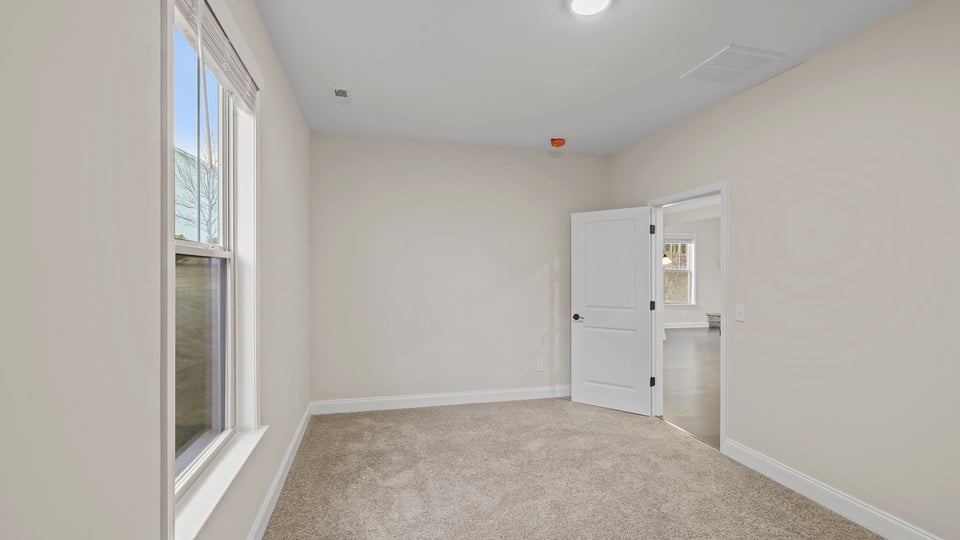 Bedroom with carpet and window.