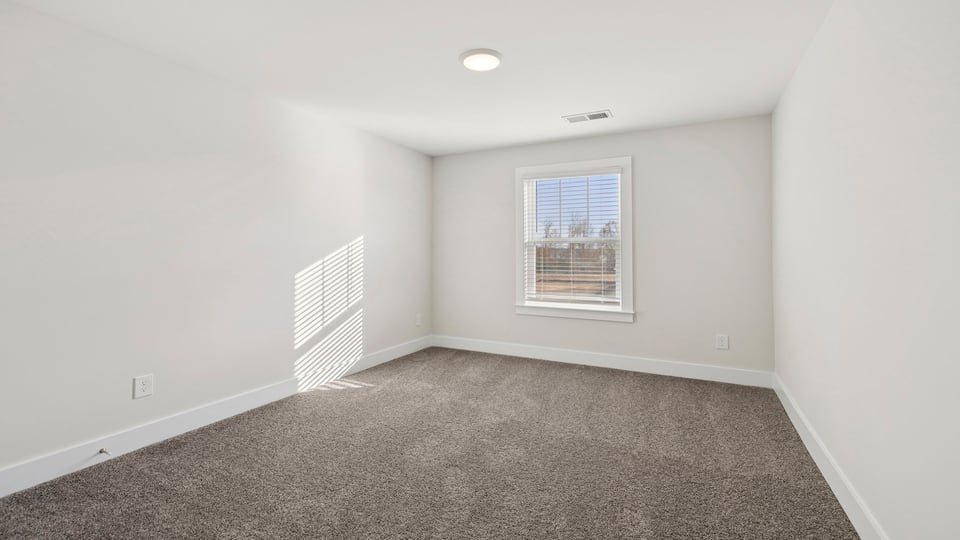 Bedroom with carpet and window.