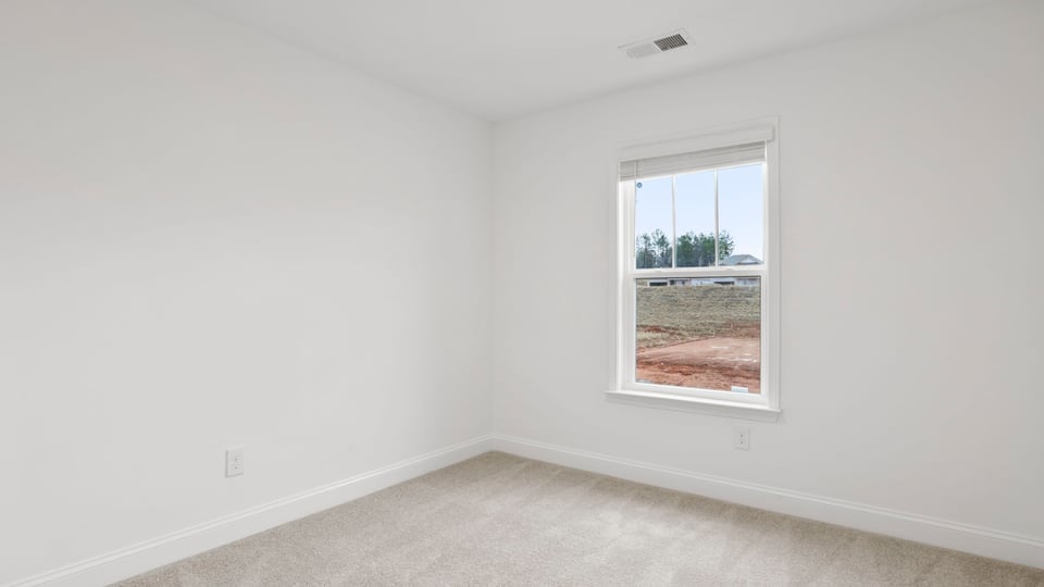 Bedroom with carpet and window.