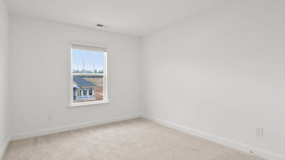 Bedroom with carpet and window.