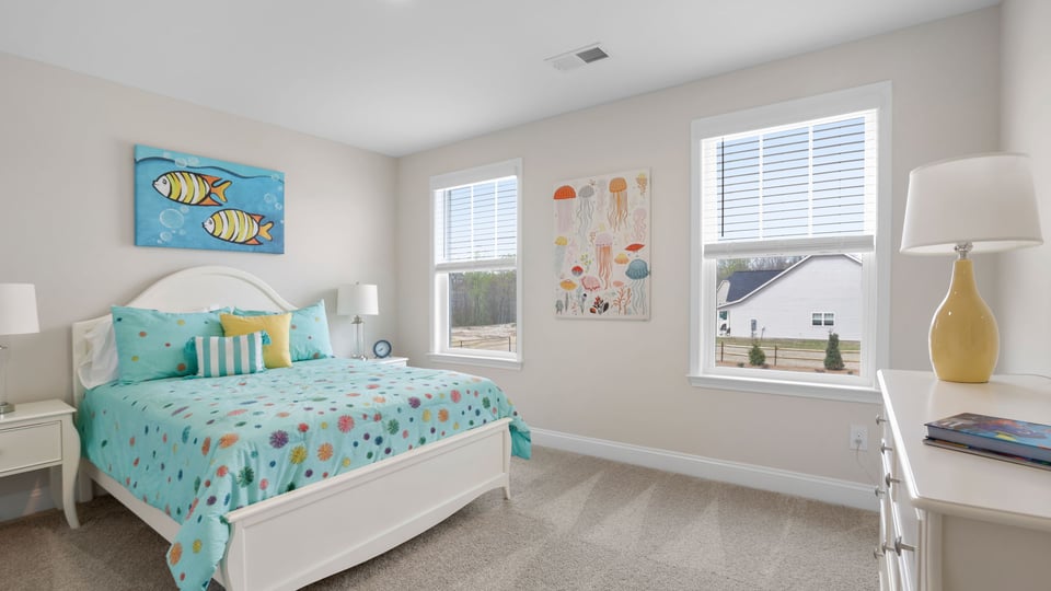 Bedroom with carpet and windows.