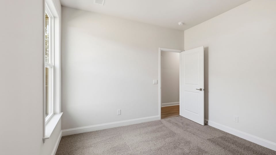 Bedroom with carpet and windows.