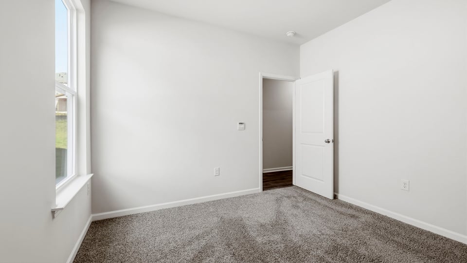 Bedroom with carpet and windows.