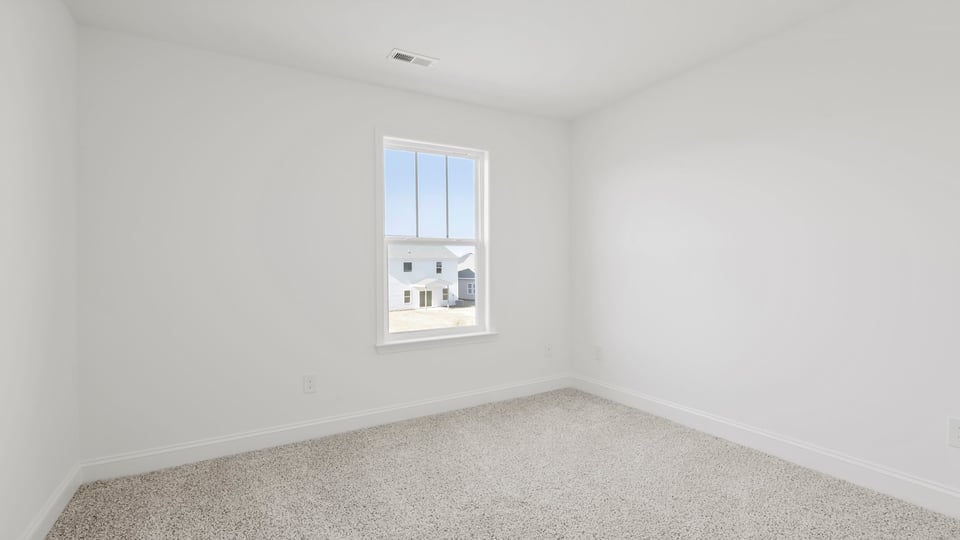Bedroom with carpet and windows.