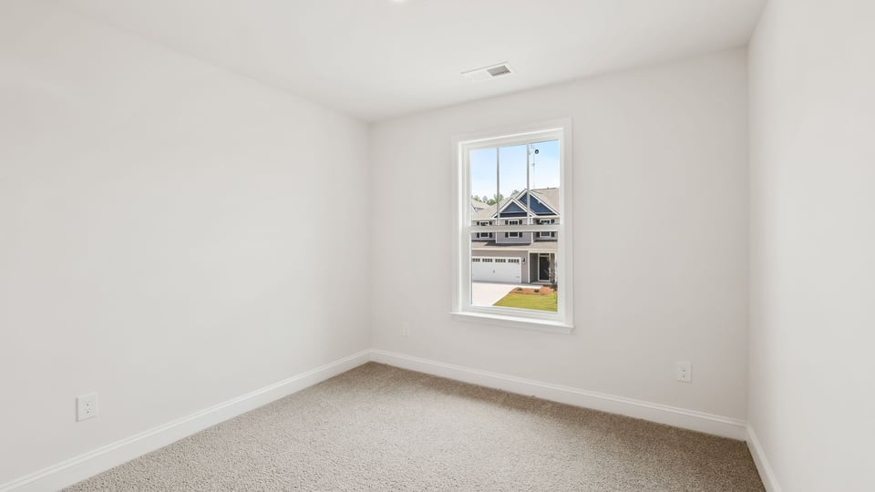 Bedroom with carpet and window.