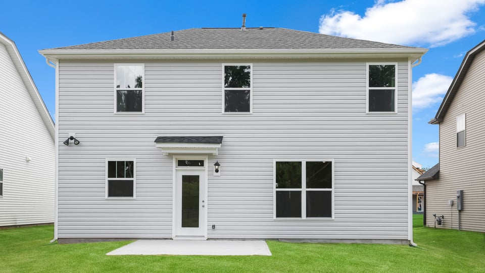 Back exterior of home with large backyard.
