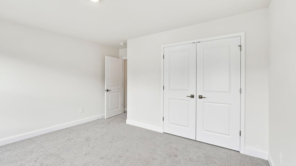 Bedroom with carpet and window.