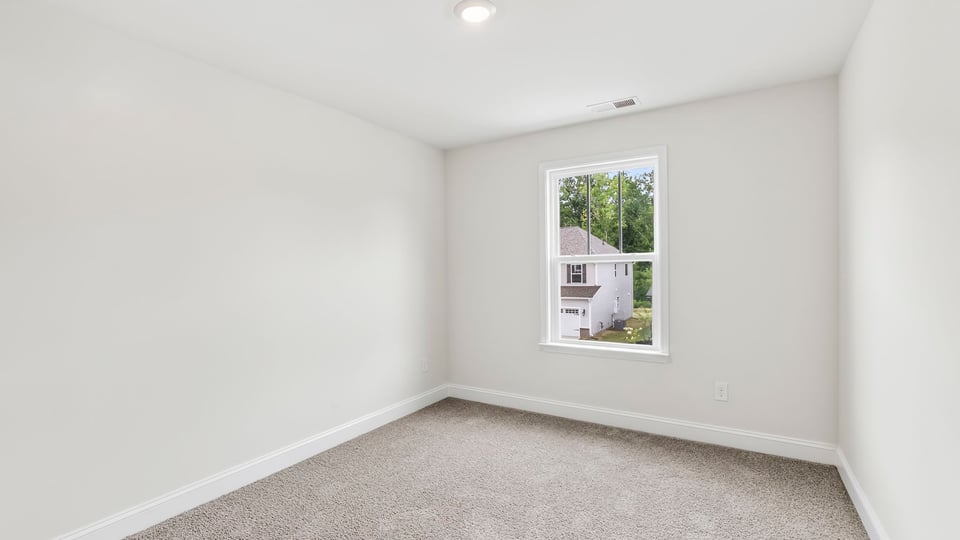 Bedroom with carpet and window.