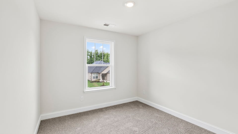 Bedroom with carpet and window.