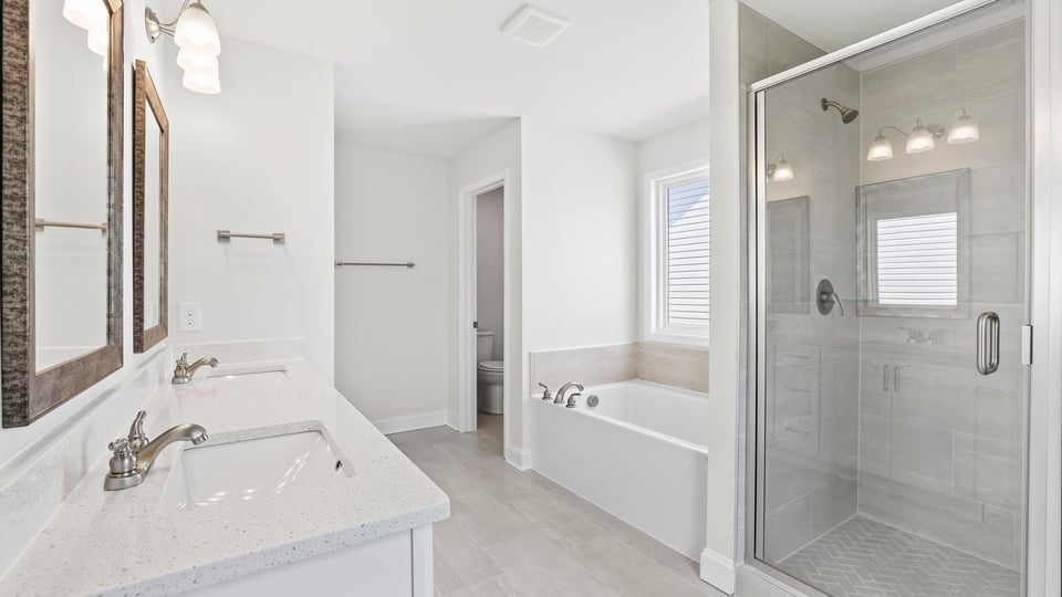 Bathroom with double vanity sink and walk in shower.