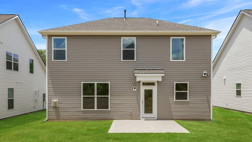 Back exterior of home with large backyard.