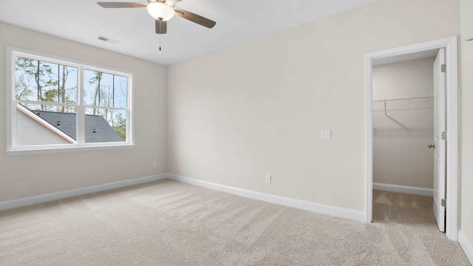 Bedroom with carpet and windows.