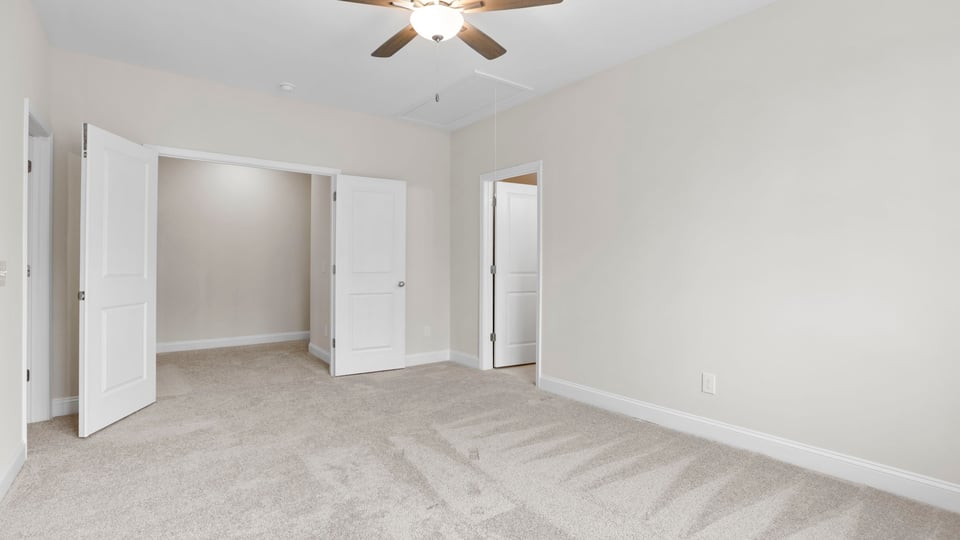 Bedroom with carpet and windows.