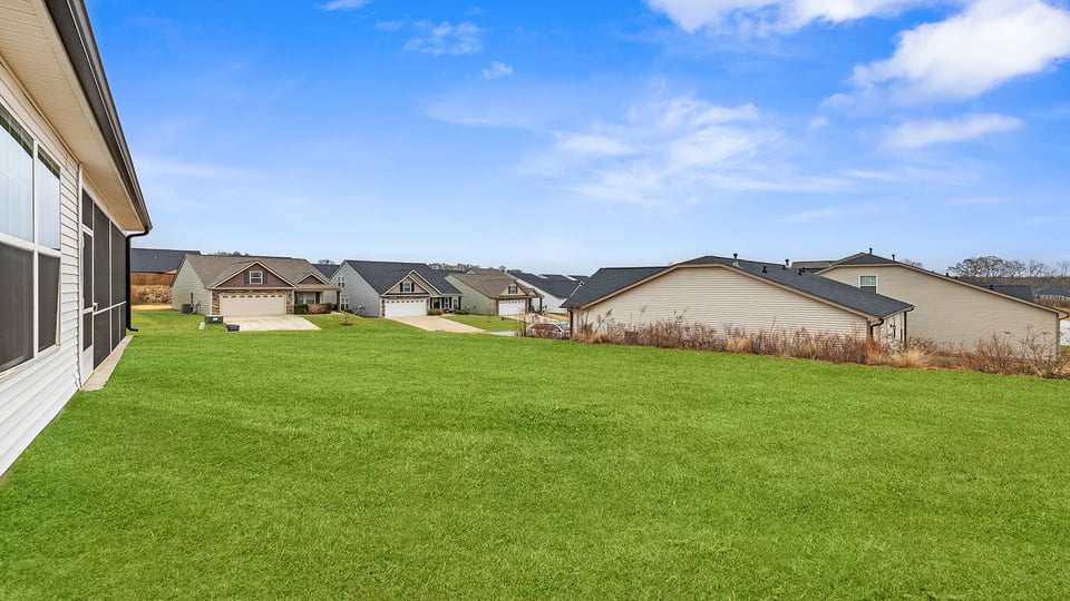 Back exterior with patio and large backyard.