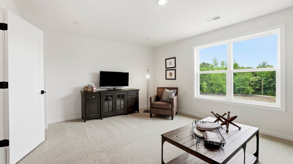 Loft area with carpet and window.