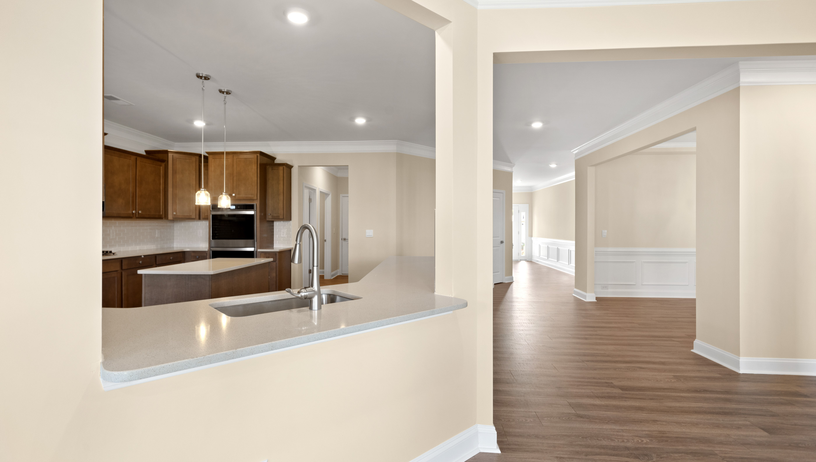 View of kitchen with opening into the kitchen.