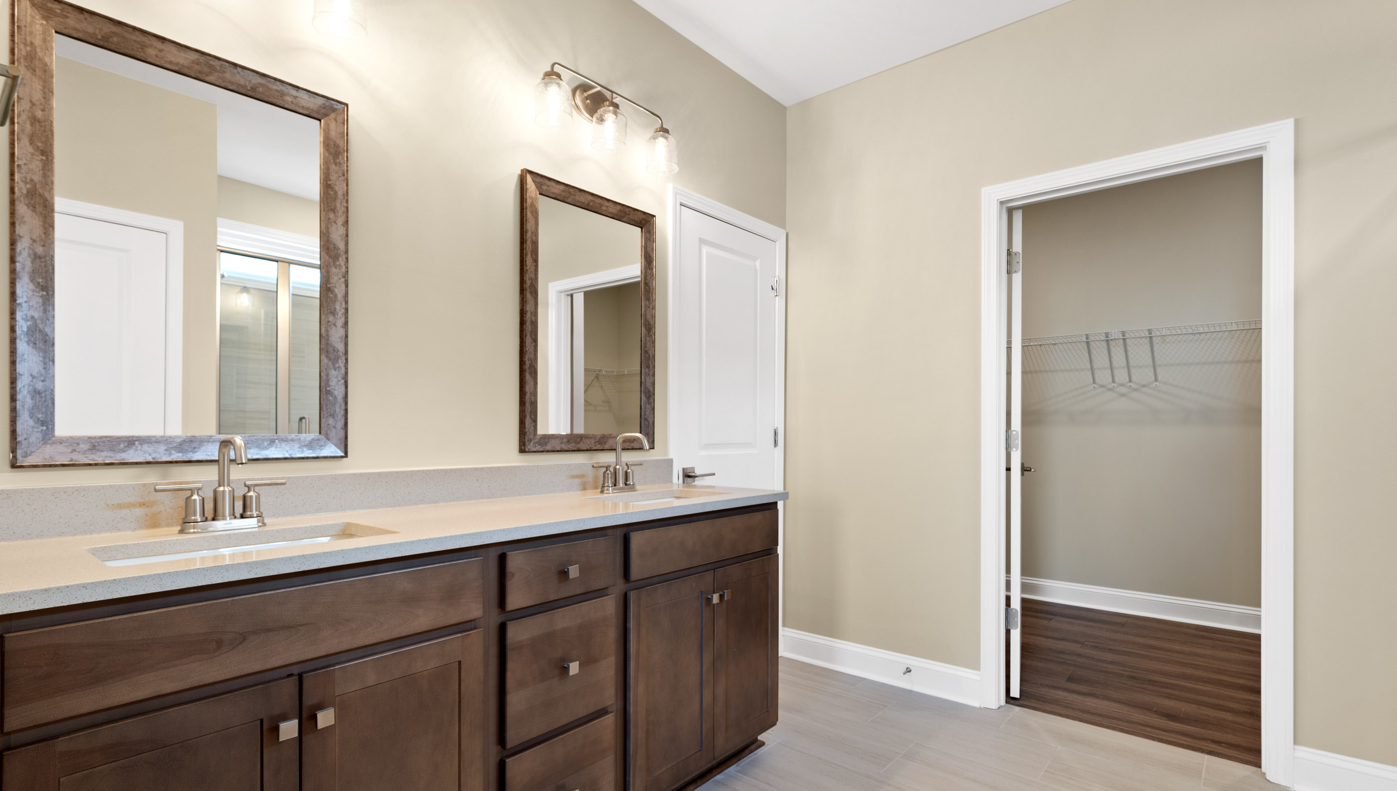 Primary bathroom with dual sink vanity and mirrors.