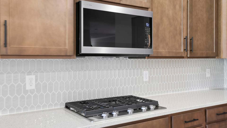 Kitchen and island with stainless steel appliances.