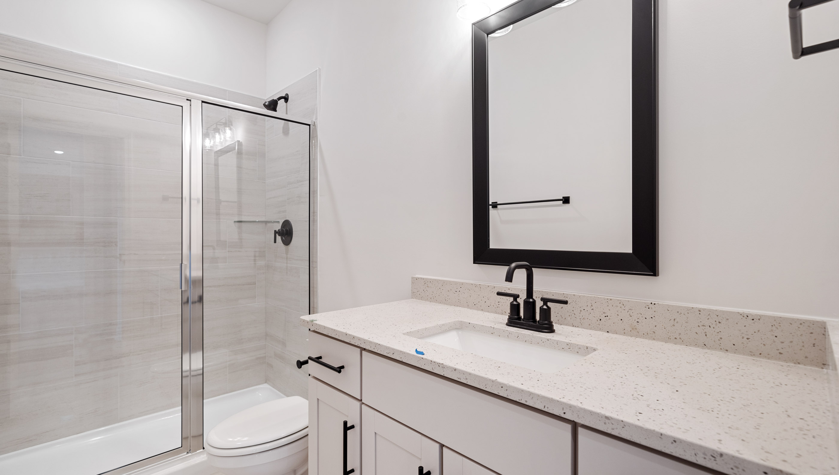 Full bathroom on the main level with walk-in shower and vanity.