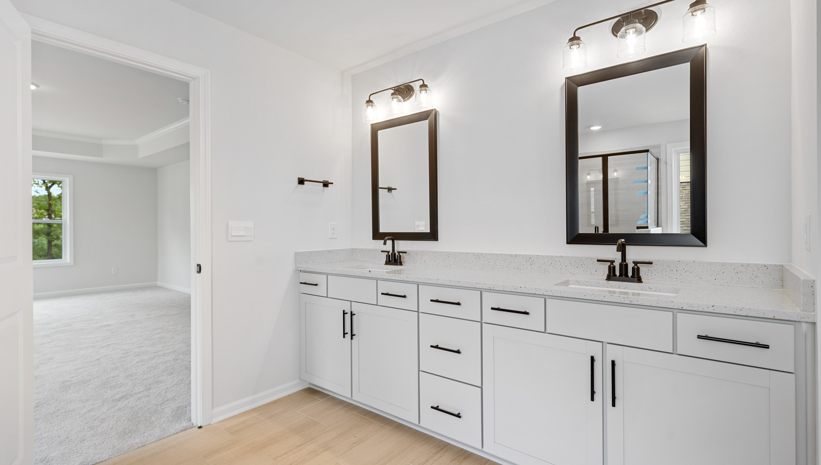 Primary bathroom with dual sink vanity and mirrors.