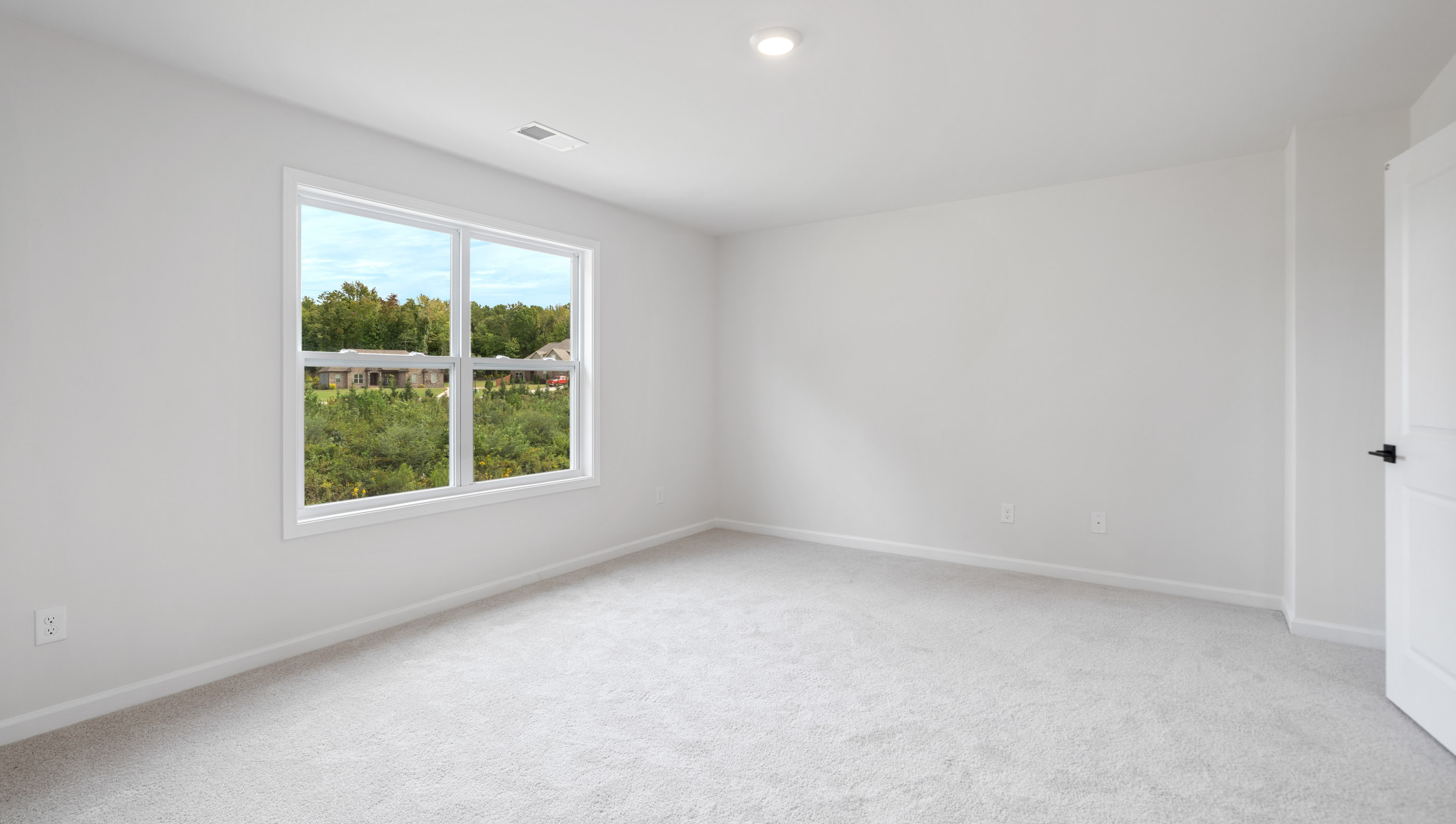 Media room with large window and carpet.