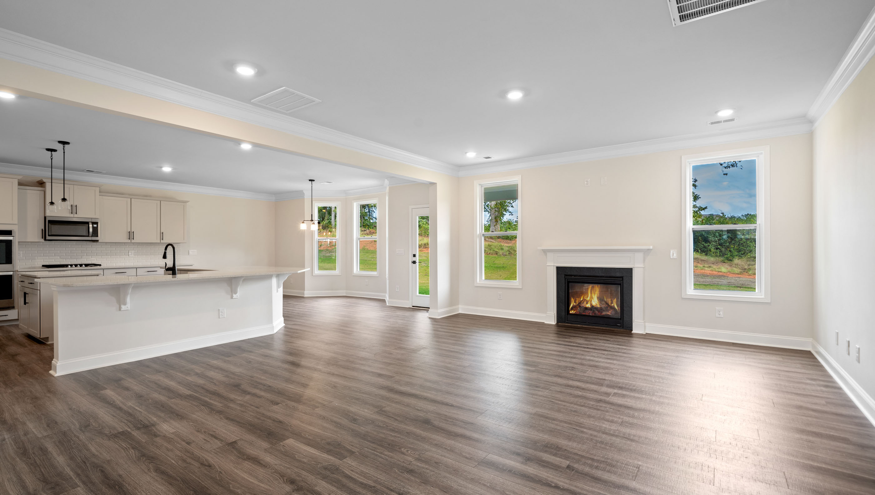 View of family room with two windows and gas log fireplace.