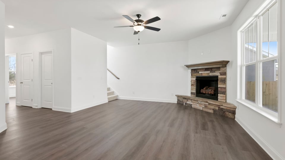 View of the family room with stone accents and large windows.