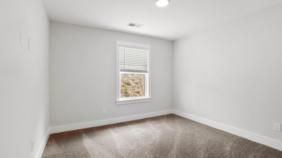Bedroom with carpet and window.