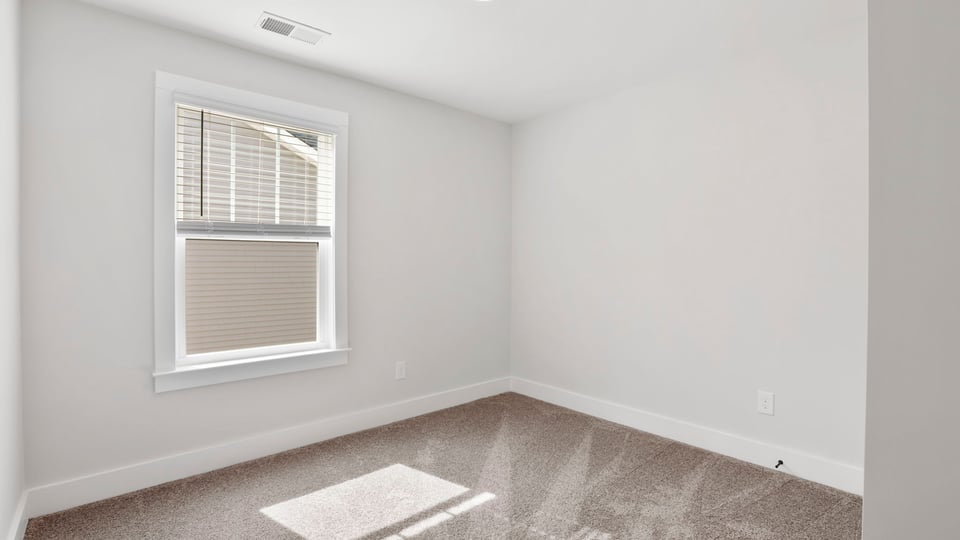 Bedroom with carpet and window.