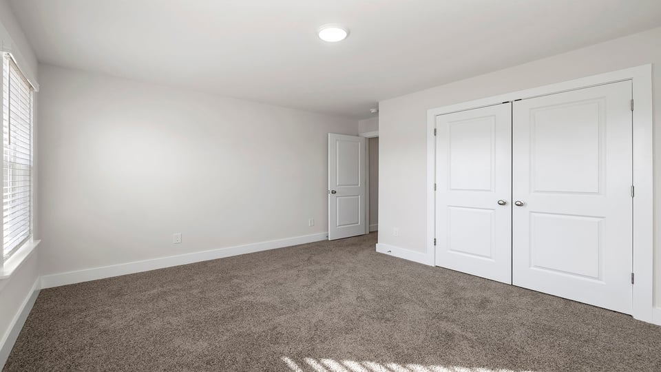 Bedroom with carpet and windows.