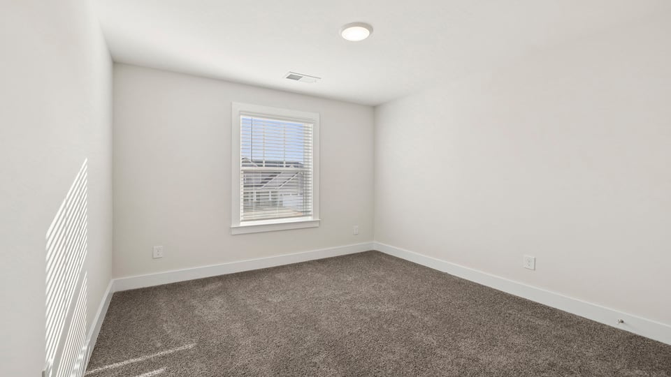 Bedroom with carpet and windows.