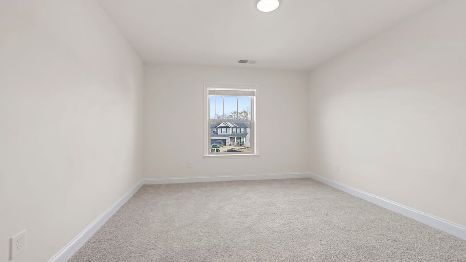 Bedroom with carpet and windows.