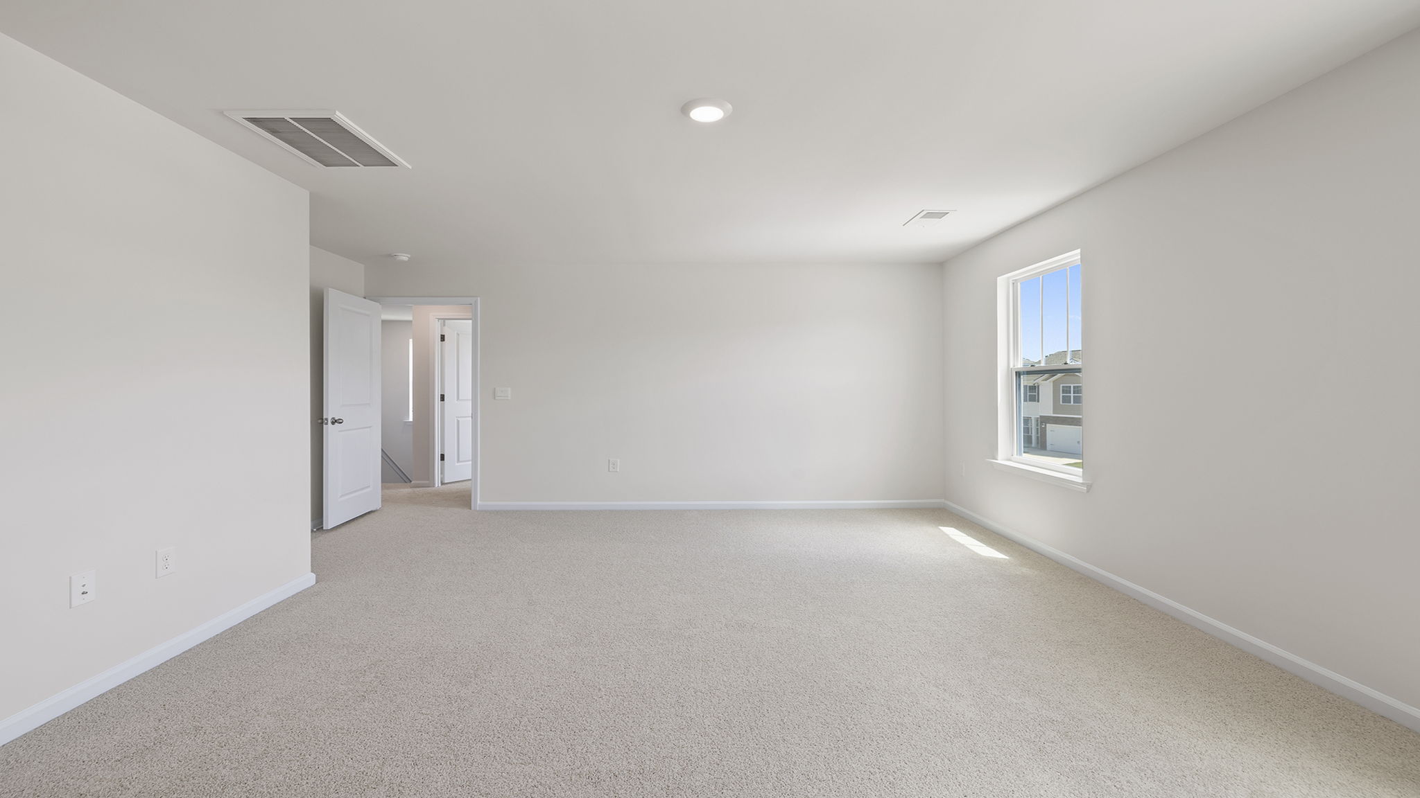 Primary bedroom with window and carpet.