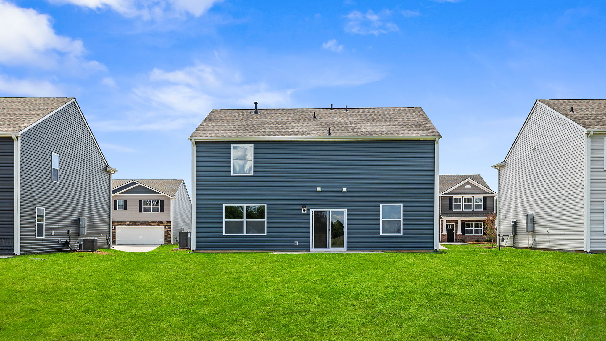 Back exterior with patio and large backyard.