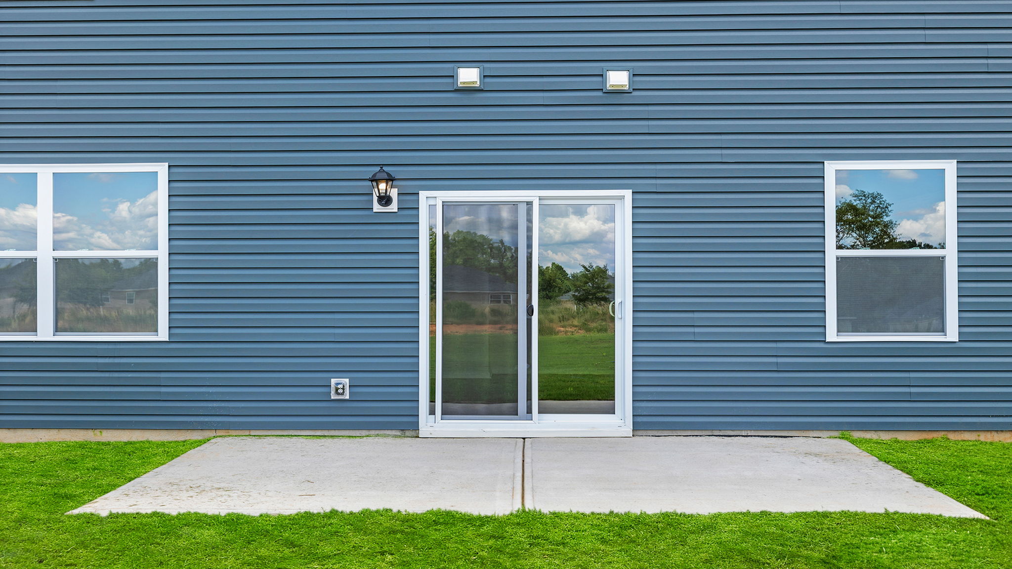 Back exterior with patio and large backyard.