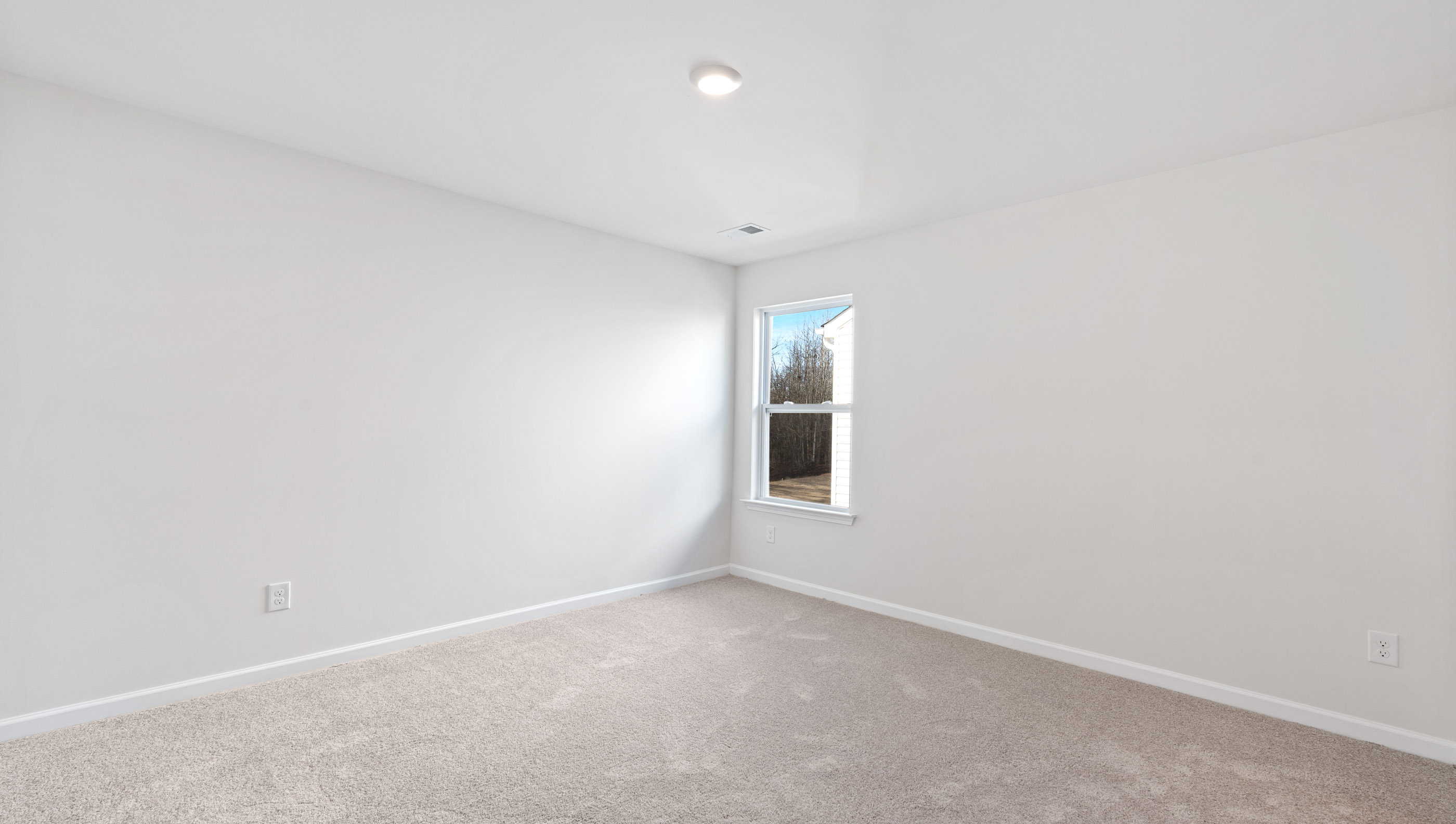 Bedroom with carpet and windows.