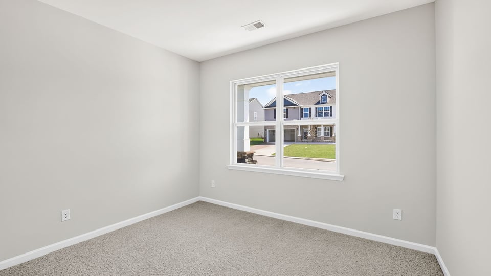 Bedroom with carpet and windows.