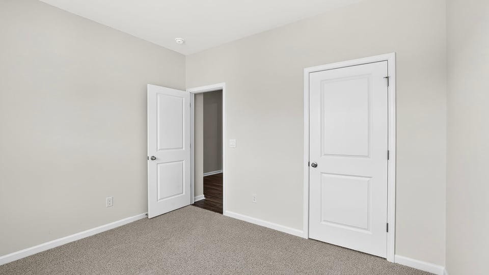 Bedroom with carpet and windows.