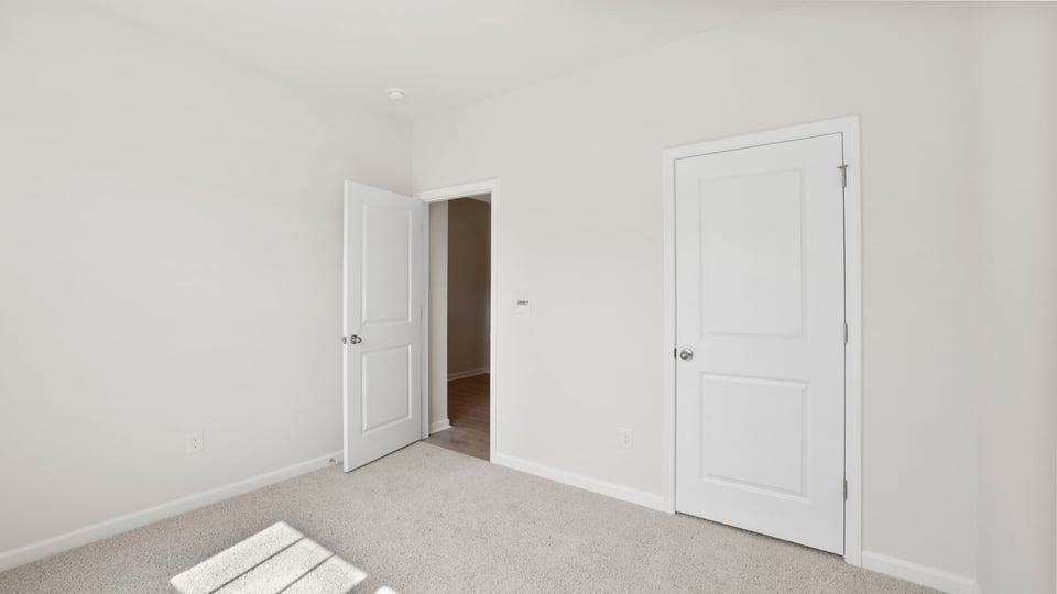 Bedroom with carpet and windows.