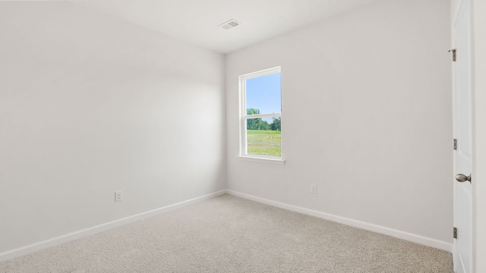 Bedroom with carpet and windows.