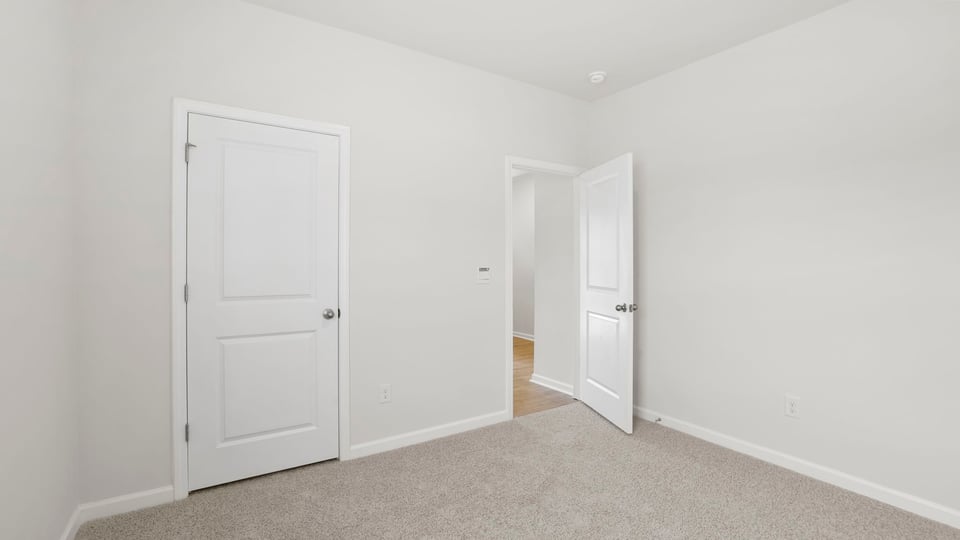 Bedroom with carpet and windows.